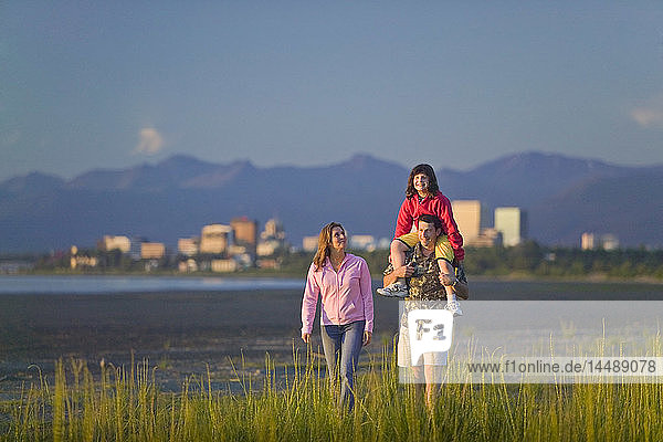 Family walking on beach along Turnagain Arm near Tony Knowles Coastal Trail Anchorage Alaska Summer SC