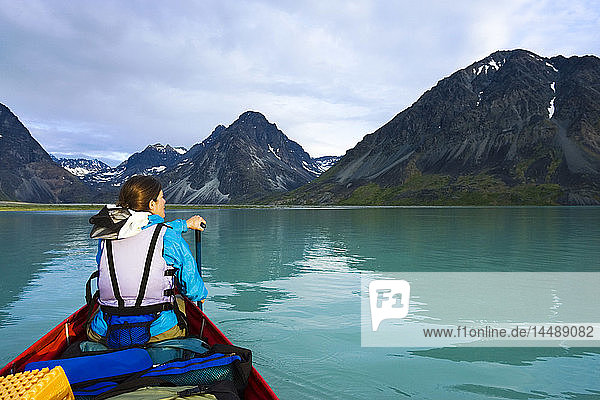 Woman canoeing in portable canoe on Turquoise Lake at Lake Clark National Park Southcentral Alaska Summer