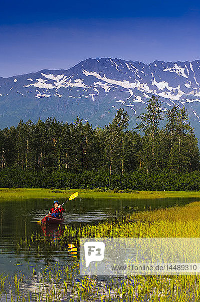 Mann in einem Kajak paddelt auf einem kleinen See im Portage Valley  Southcentral  Alaska  Sommer