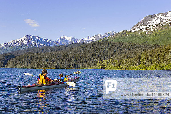 Father & son sea kayaking in tandem kayak on Bear Lake Kenai Peninsula Alaska Summer