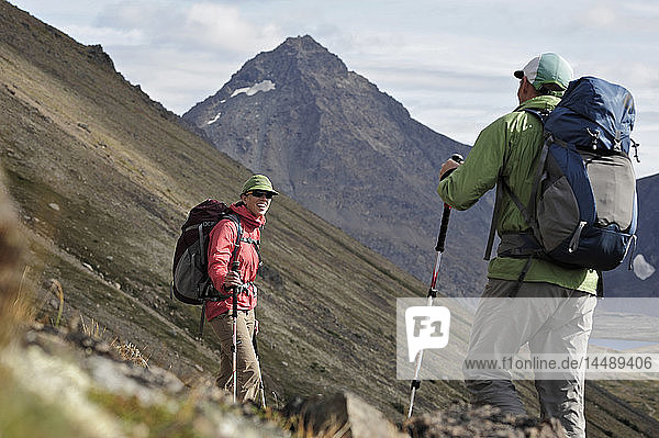 Two backpackers hiking to Ptarmigan Pass  Chugach State Park  Southcentral Alaska  Summer