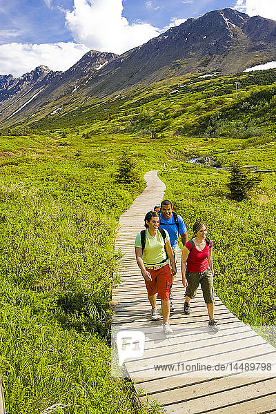 Familienwanderung auf dem Holzsteg des Middle Fork Loop Trail im Gebiet der Glen Alps im Chugach State Park  Süd-Zentral-Alaska