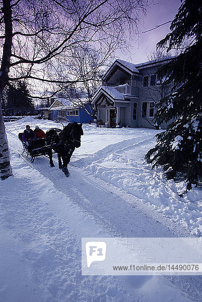 People on Sleigh Ride in Front of House Anchorage AK