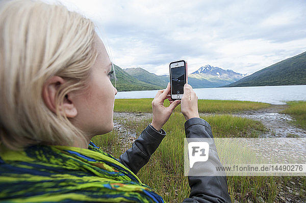 Frau fotografiert mit einem Smartphone den Eklutna-See  Chugach State Park  Süd-Zentral-Alaska
