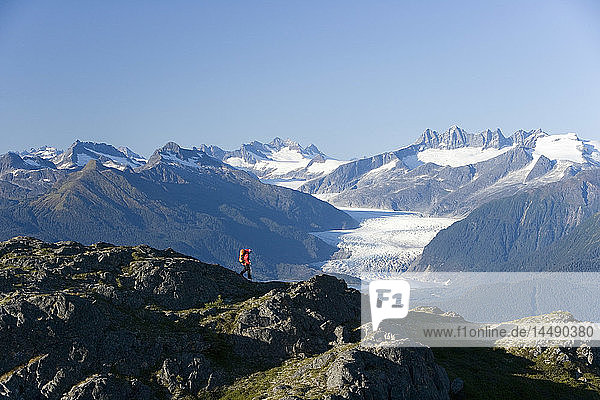 Man hiking in Alaska´s Tongass National Forest with view of Mendenhall Glacier near Juneau Alaska southeast Autumn