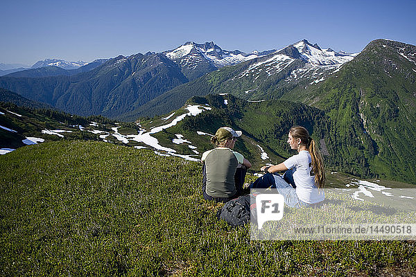 Hikers rest and admire the view in the alpine above Amalga Basin in the Tongass Forest  near Juneau  Alaska.