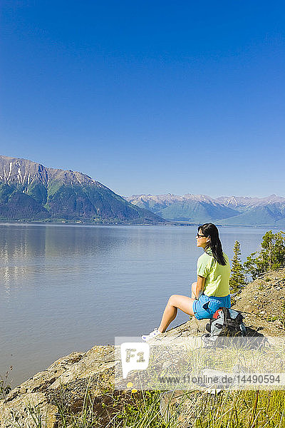 Wanderin mit Blick auf den Turnagain Arm und die Kenai Mountains vom Coastal Trail in der Nähe von Bird Creek in Süd-Zentral-Alaska