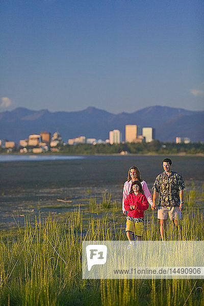 Family walking on beach along Turnagain Arm near Tony Knowles Coastal Trail Anchorage Alaska Summer SC