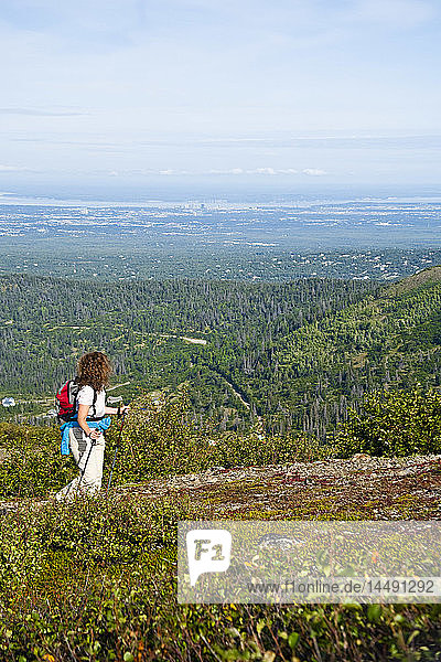 Woman hiking on McHugh Peak trail in Chugach State Park with Anchorage  Alaska in background