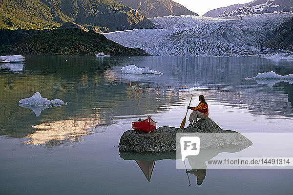 Woman Sitting on Rock Outcrop w/Canoe Mendenhall Lake SE AK