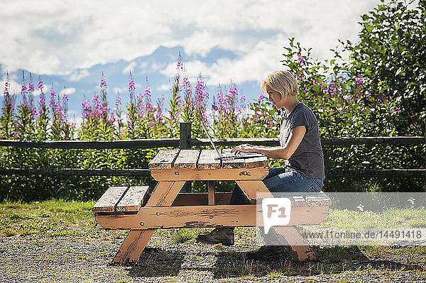 Frau bei der Arbeit am Laptop am Cook Inlet in der Nähe von Homer  Kenai-Halbinsel  Southcentral Alaska