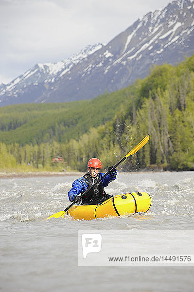 Woman paddles in a pack raft in the Matanuska River in Southcentral Alaska