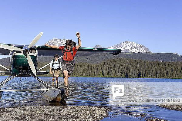 Menschen springen vom Wasserflugzeug zum Ufer des Sees  um zu wandern Kenai Mtns Kenai Peninsula Alaska Sommer