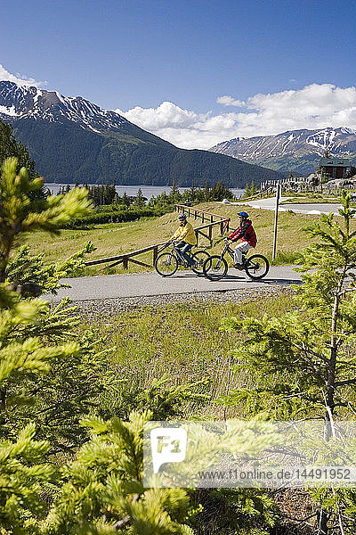 Junges Paar Fahrräder auf Pfad @ Bird Pt Rest Stop AK SC Turnagain Arm Chugach Mtns Sommer
