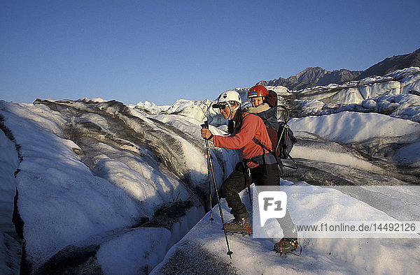 Frau beim Eisklettern mit Kind auf dem Rücken Matanuska-Gletscher