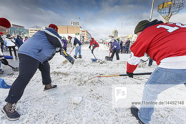 Freiwillige Helfer schaufeln an einer Straßenkreuzung in der 4th Avenue während des feierlichen Starttages des Iditarod 2015 in Anchorage  Alaska  den Schnee zurück auf die Strecke