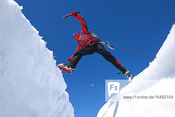Eiskletterer springt über eine Gletscherspalte auf dem Matanuska-Gletscher SC AK
