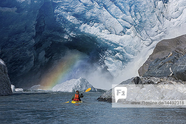 A kayaker explores a melt stream gushing from beneath Mendenhall Glacier  Mendenhall Lake  Tongass National Forest  Juneau  Alaska