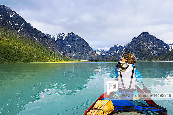 Woman canoeing in portable canoe on Turquoise Lake at Lake Clark National Park Southcentral Alaska Summer