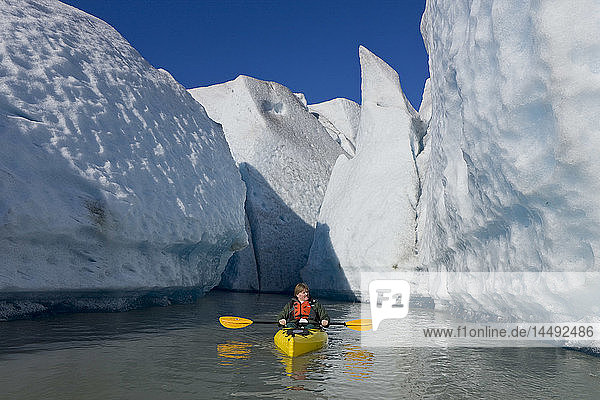 A kayaker paddles and explores the seracs of Mendenhall Glacier on a crisp Fall morning  Southeast Alaska