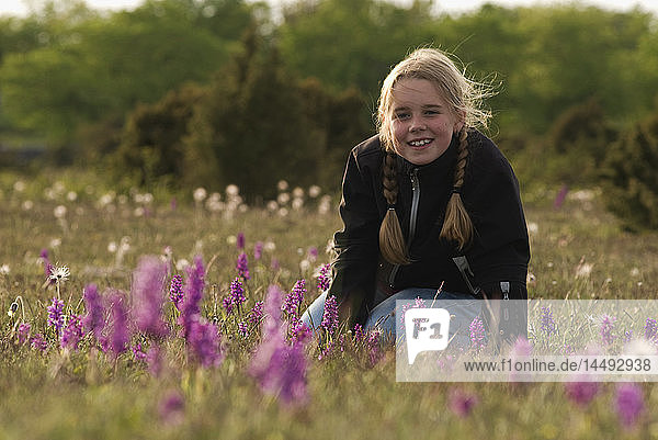 Girl on meadow looking at camera and smiling