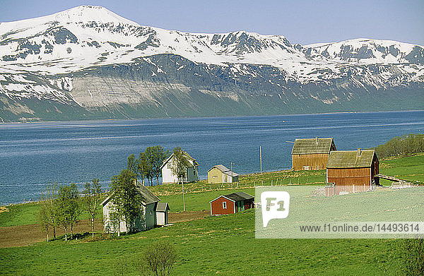 Fjord vorbei an schneebedeckten Bergen und Häusern