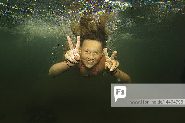 Ein Mädchen schwimmt unter Wasser  Schweden.