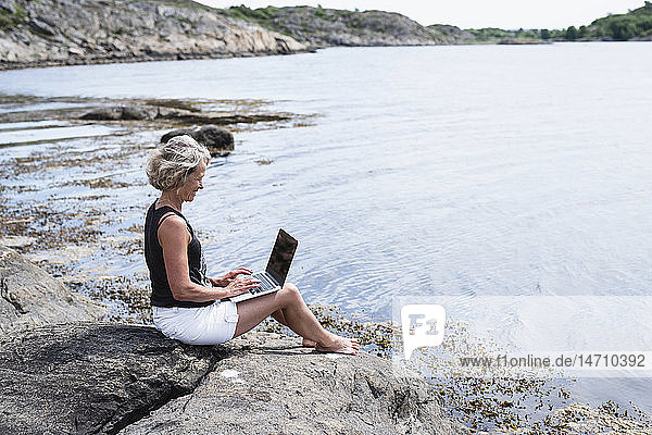 Frau benutzt Laptop auf See
