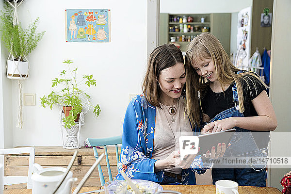 Mother with daughter looking at digital tablet