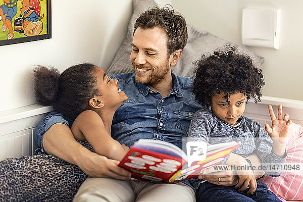 Father reading book to children