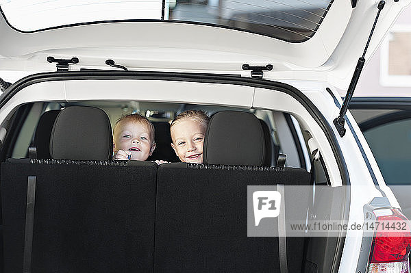 Lächelnder Junge und lächelndes Mädchen im Auto