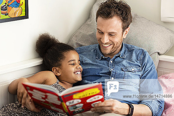 Vater liest seiner Tochter ein Buch vor