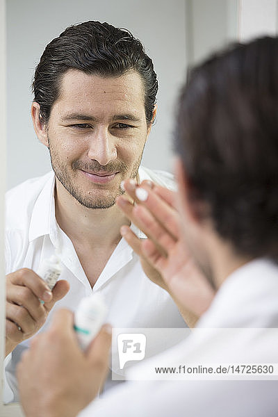 Man applying face cream.