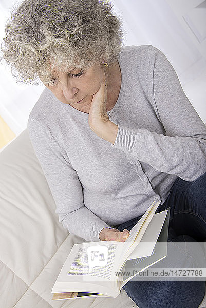 Ältere Frau liest ein Buch.