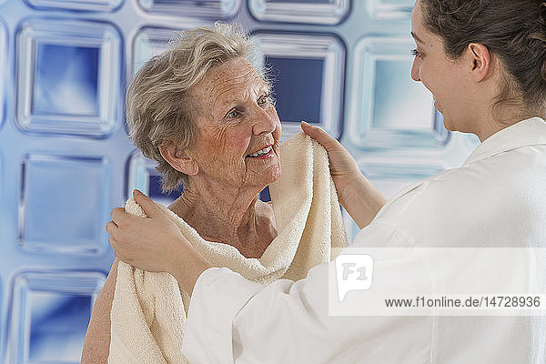 Krankenschwester hilft einer älteren Frau beim Waschen.