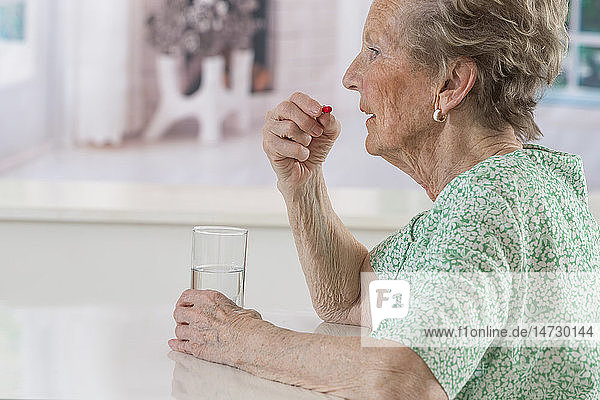 Senior woman taking a medicine.
