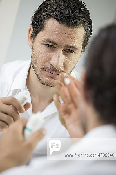 Man applying face cream.