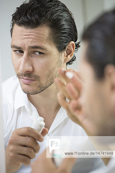 Man applying face cream.