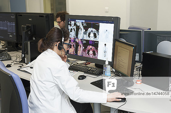 Reportage on PET imaging at the Antoine-Lacassagne Cancer centre in Nice  France. Positron Emission Tomography  or PET scan  is used in diagnosing and monitoring patients with cancer. This method enables tumours to be detected using a radioactive tracer  which accumulates heavily in cells that present a pathological hypermetabolism. The scintigraphy doctors interpret the results and write up their reports.