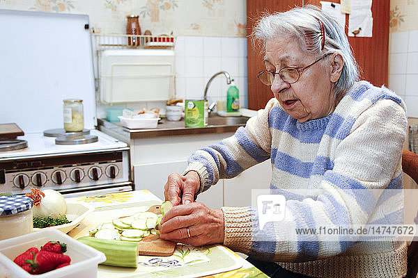 Eine ältere Frau kocht in ihrem Haus  unterstützt von ihrer Tochter  die ihr Vormund ist.