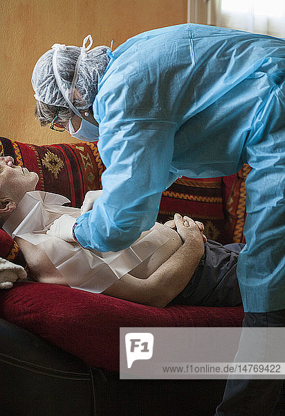 Reportage über einen häuslichen Pflegedienst in Savoie  Frankreich. Eine Krankenschwester wechselt bei einer Krebspatientin den Chemotherapie-Tropf.