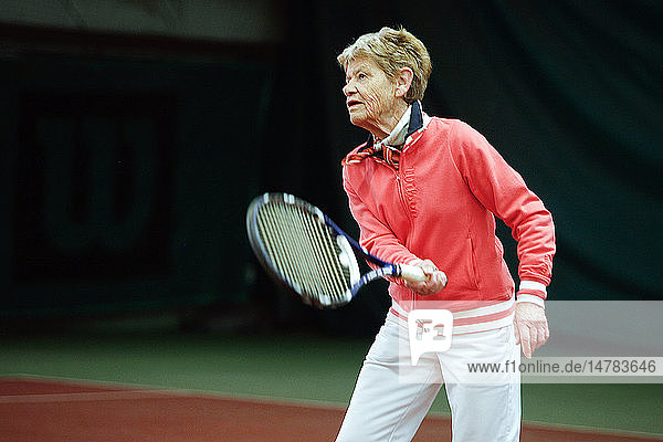 Eine ältere Person spielt Tennis.