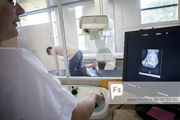 Reportage in a radiology centre in Haute-Savoie  France. A technician carries out a foot x-ray on a patient who had an operation on a hallux valgus.