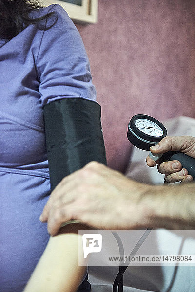 Reportage on a midwife in Lyon  France during a prenatal consultation. Taking a patient’s blood pressure is one of the vital tests to check a patient’s health.