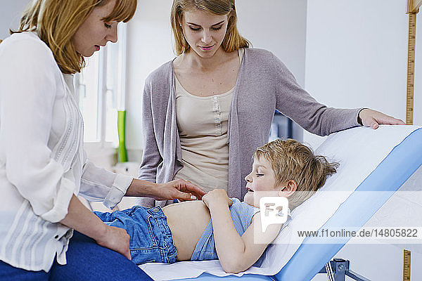 Ein Arzt untersucht den Unterleib eines Kindes.