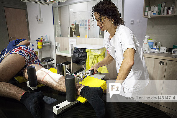 Reportage in einem Zentrum für Radiologie in Hochsavoyen. Ein Techniker führt eine dynamische Röntgenaufnahme des Knies nach einem Bänderriss durch.