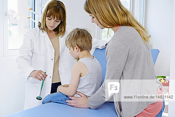 Doctor testing a child´s knee jerk reflex.