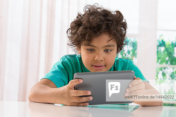 Junge schaut auf ein digitales Tablet.