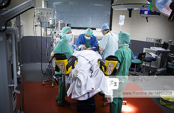 Reportage in einem Operationssaal während einer Hysterektomie mit dem da Vinci Roboter®. Der Anästhesist und die Anästhesieschwester bereiten die Patientin auf die Operation vor.