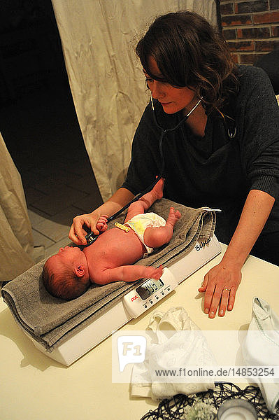 Reportage aus der Praxis einer freiberuflichen Hebamme in Ham  in der Region Somme in Frankreich  bei Hausbesuchen. Besuch nach der Entbindung: Die Hebamme untersucht das Neugeborene.